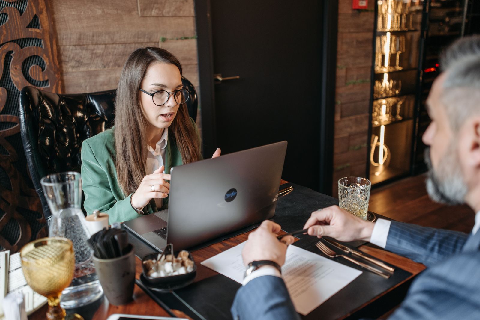 Business consulting services in practice: a consultant with a laptop walks a business owner through a written plan